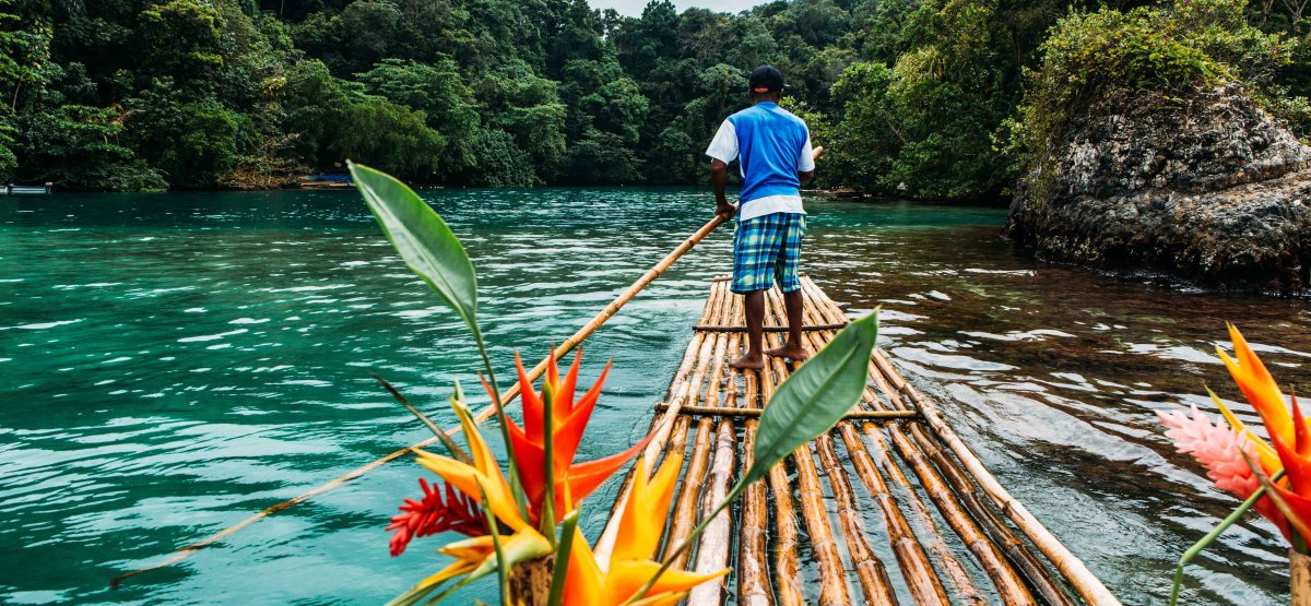 Bamboo rafting in Jamaica along clear water river with guide.