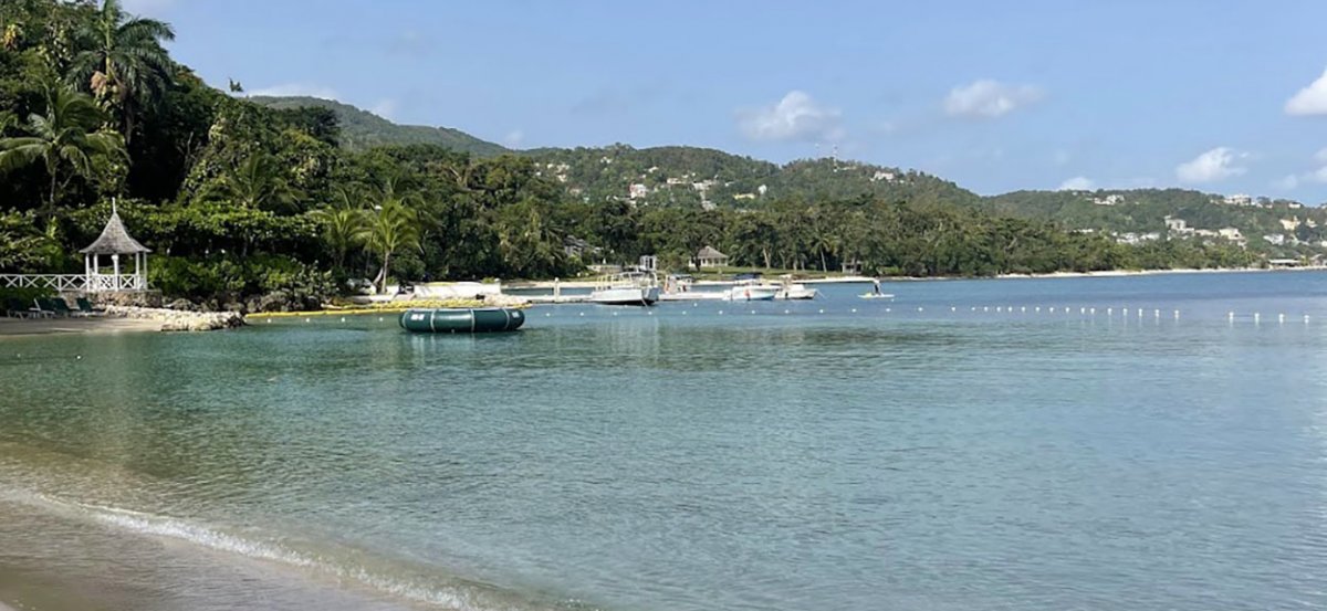 Round Hill Beach arc of the beach looking towards forested hills. 