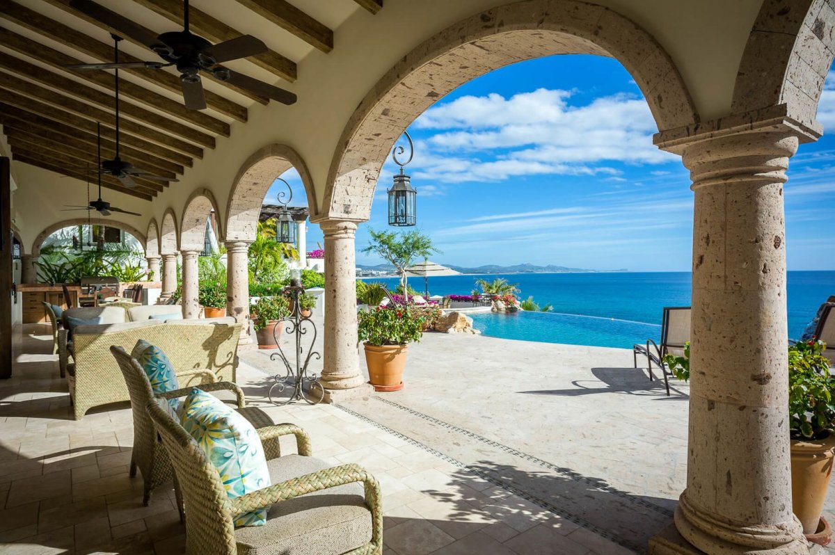 Step through grand columned archways towards the covered patio area