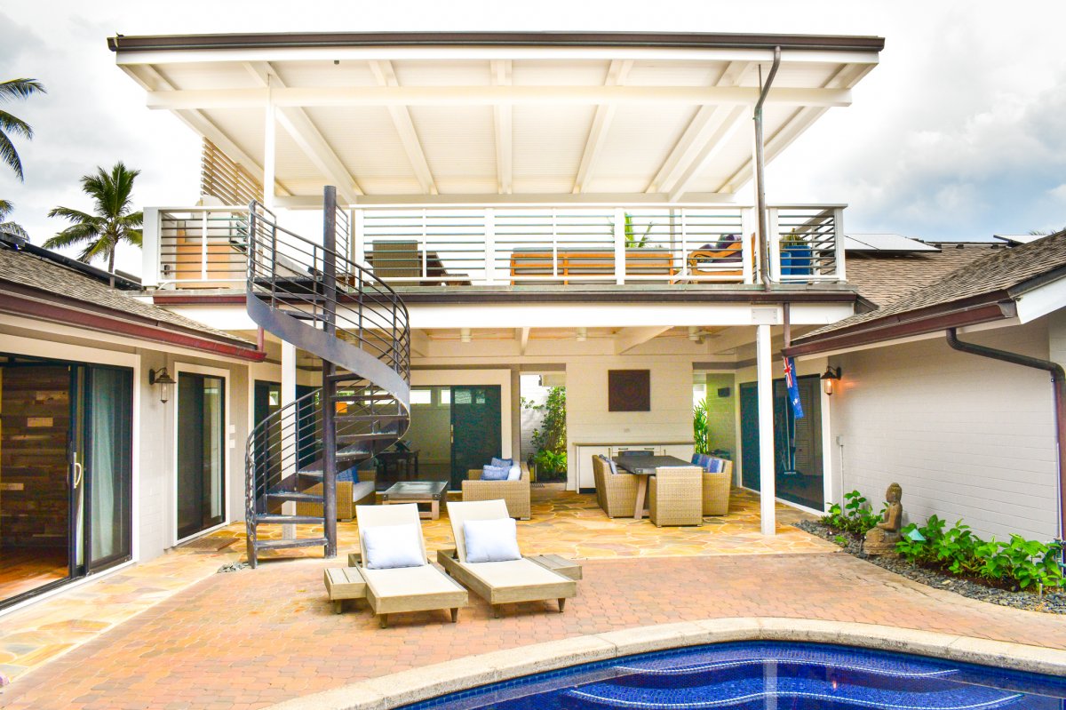 Spacious outdoor area with swimming pool, lounge chairs, and a beautiful rooftop deck at Hale Ohana on Oahu