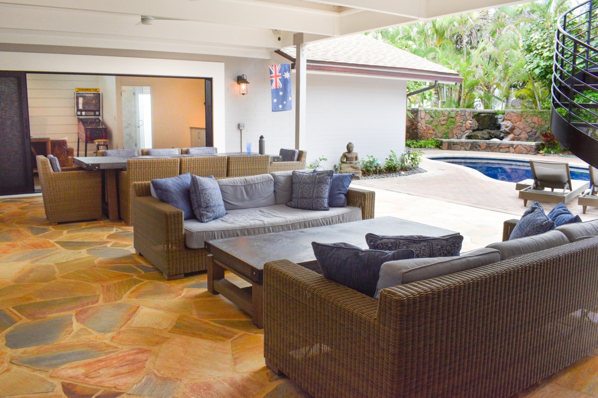 Hale Ohana's covered lanai with ceiling fans interconnecting with the indoor living area and the swimming pool area