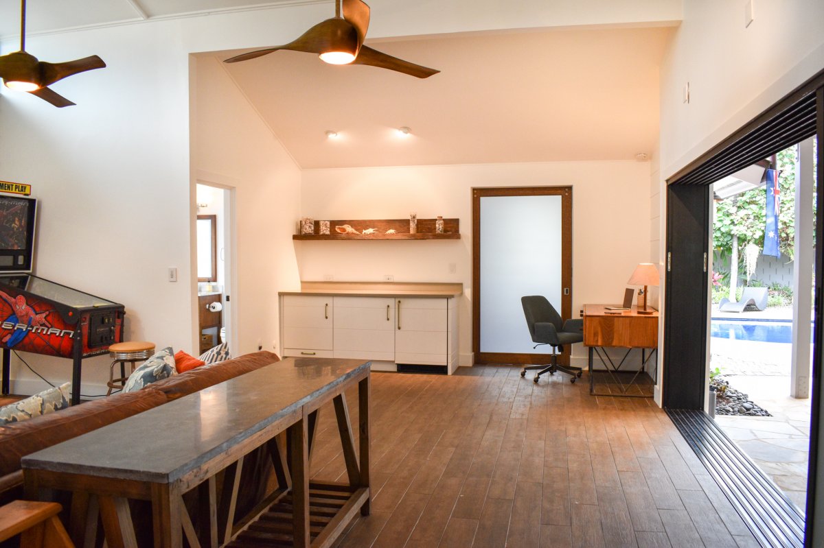 Living room space with office workspace in the corner and access to the covered lanai