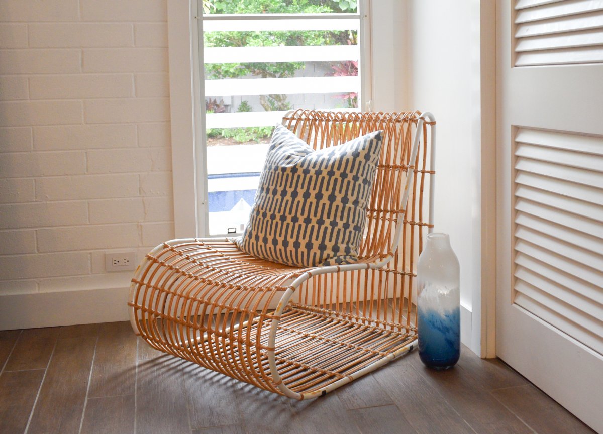 Relax in style at Hale Ohana's rattan-polished lounge chair