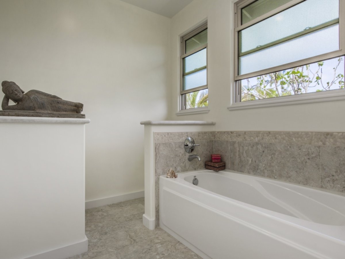 Primary bath with a freestanding bathtub and a raised platform with a reclining Buddha statue