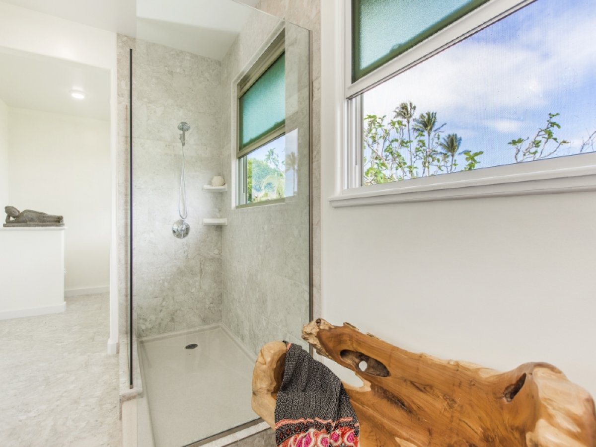 Primary bath's walk-in shower with outdoor views from the window