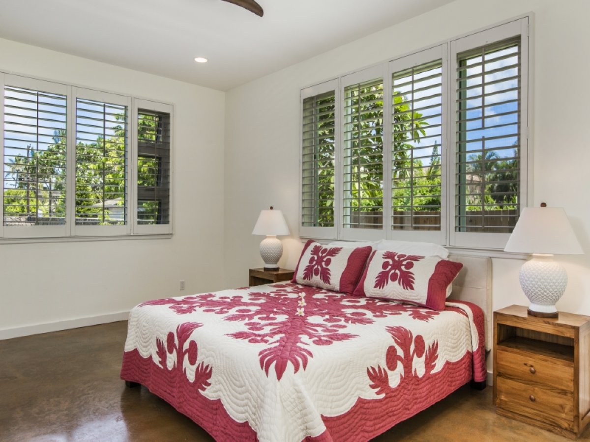 Primary bedroom featuring adjustable plantation shutter with views of the lush greenery outside