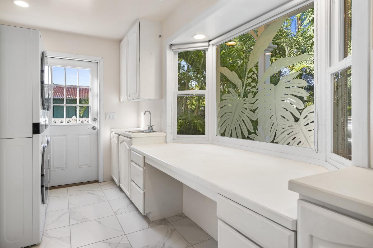 Spacious laundry and pantry area with plenty of counter space and storage.