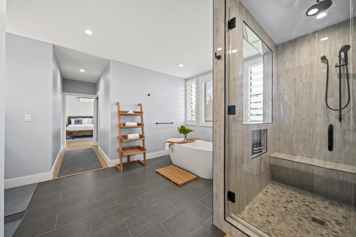A spacious bath complete with glass shower, soaking tub, and clean contemporary design.