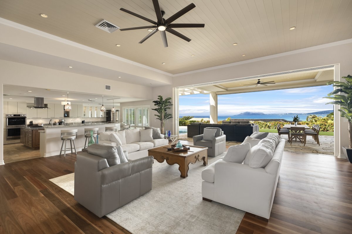 Hale Makana's open-concept living room with direct access to the lanai, and ocean views, and next to it is the kitchen