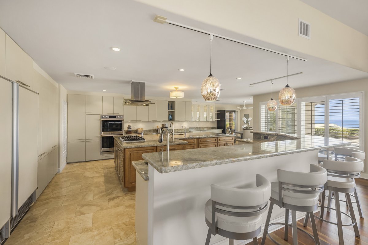 Hale Makana's large and modern kitchen with a large island, a breakfast bar, and well-equipped with stainless steel appliances