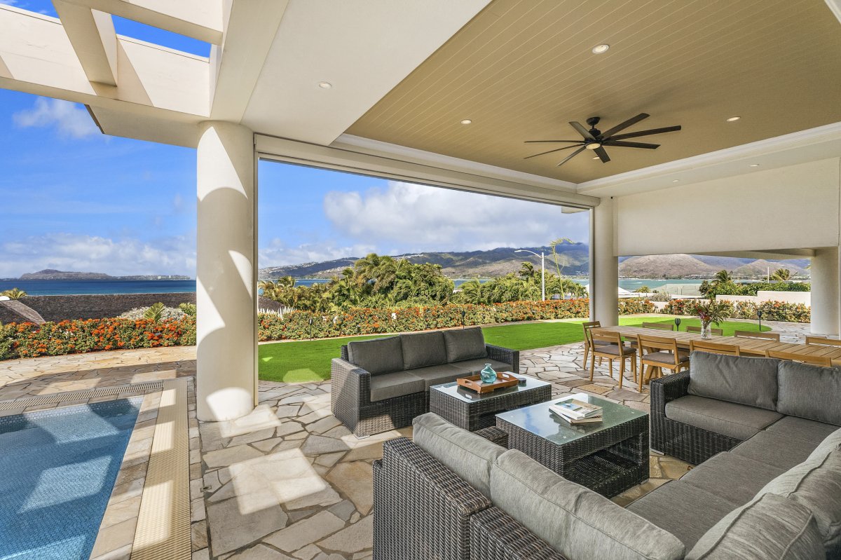 Hale Makana's covered lanai with a ceiling fan, comfortable lounge chairs, and breathtaking views of the sparkling blue ocean