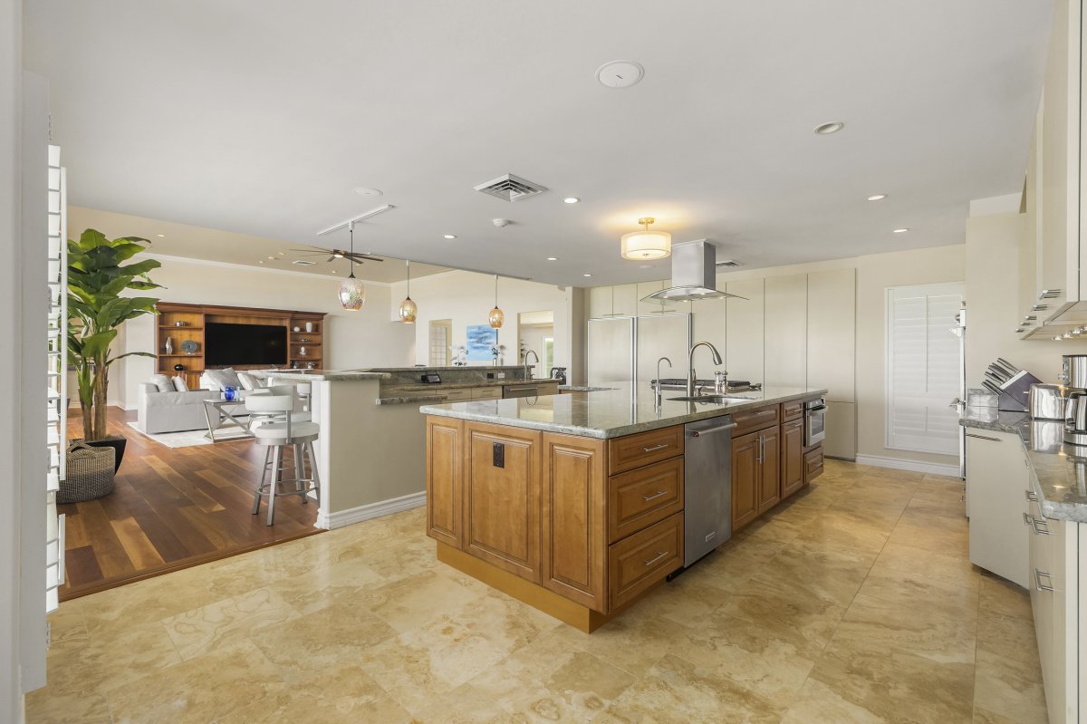 Modern kitchen with white cabinets, granite counters, stainless steel appliances, and a large island