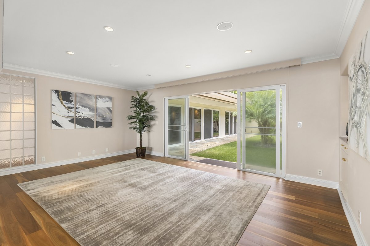 Hale Makana's open space features elegant hardwood floors and large sliding glass doors leading to a lush garden