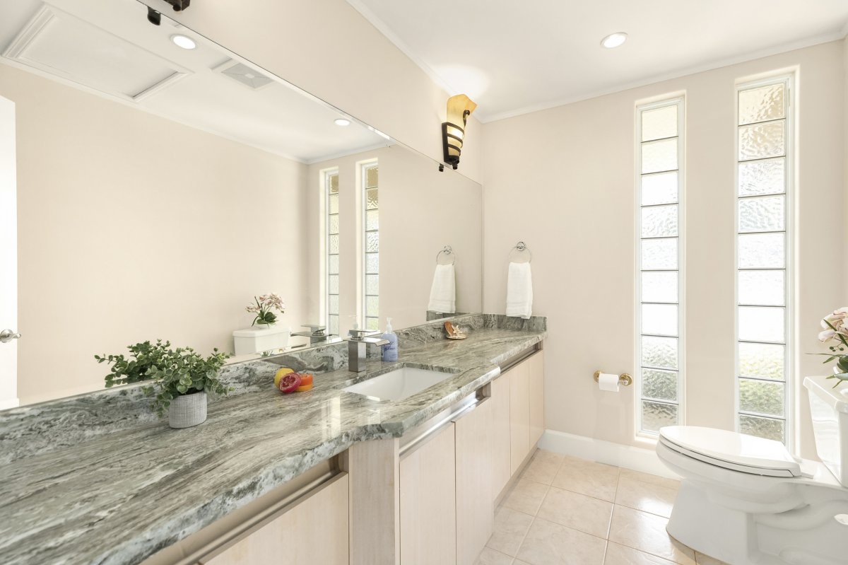 Hale Makana's contemporary aesthetic designed bathroom with a polished granite countertop and a modern sink