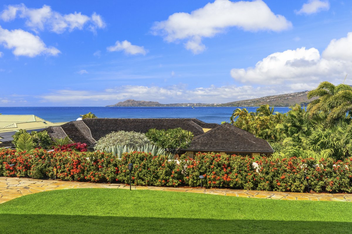 Breathtaking view from Hale Makana featuring a lush, well-manicured garden bordered by vibrant flowering plants