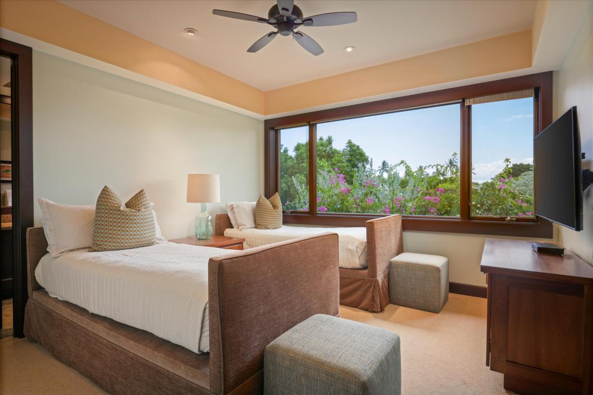 Guest bedroom with tropical garden views, soft neutral tones, and direct lanai access.