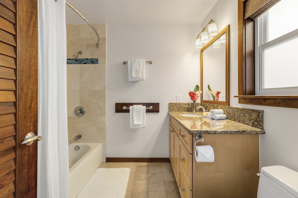 Hale Makai's Second En-suite with a bathtub, a vanity with drawers and cabinets and a toilet