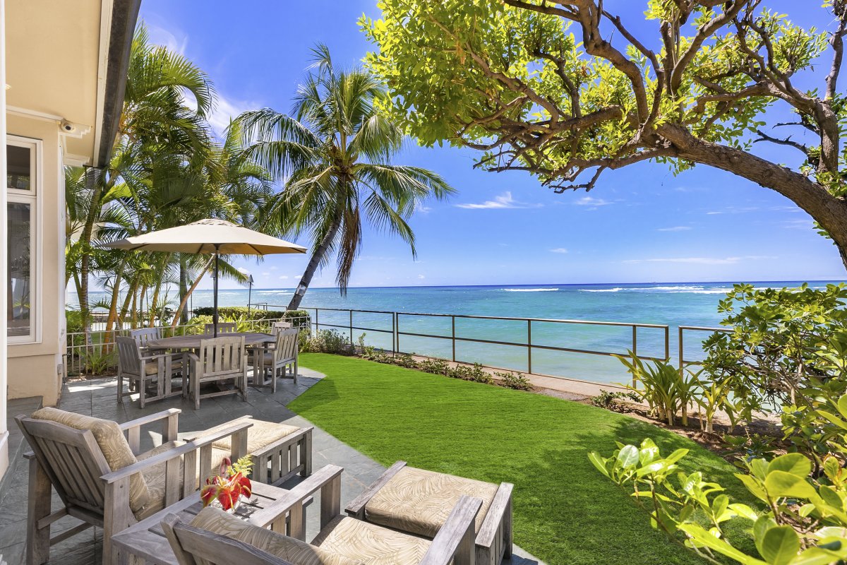 Diamond Head Surf House lanai with ocean views, cushioned lounge chairs, and table seating options