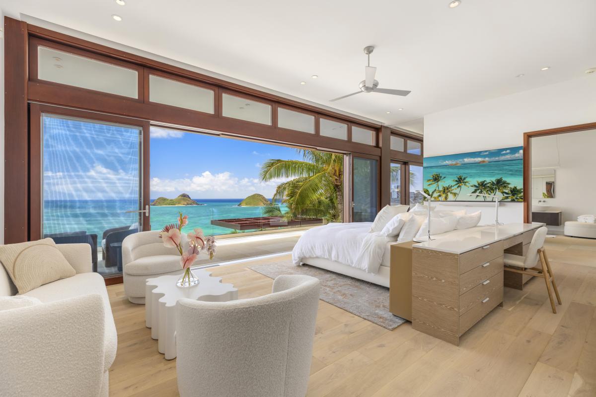 Primary bedroom with a king-sized bed and expansive ocean views, offering ultimate comfort and luxury.