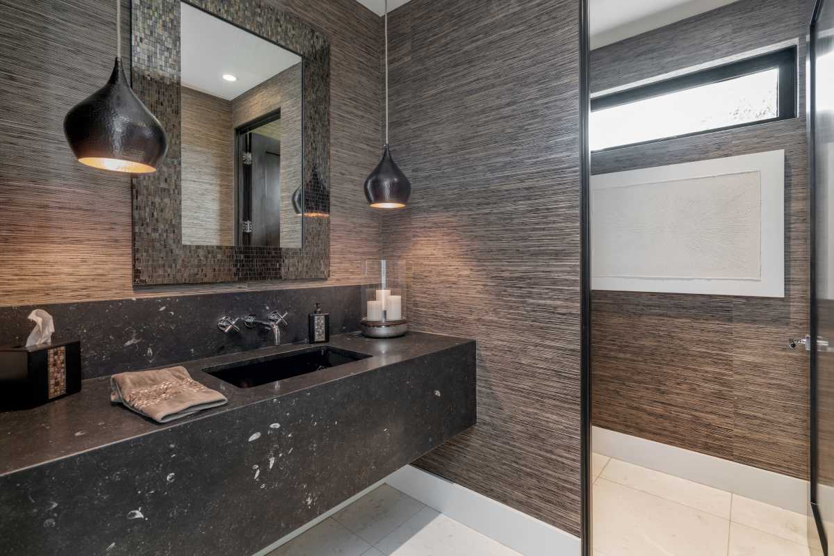 Elegant bathroom with a sink, toilet, and glass-doored walk-in shower