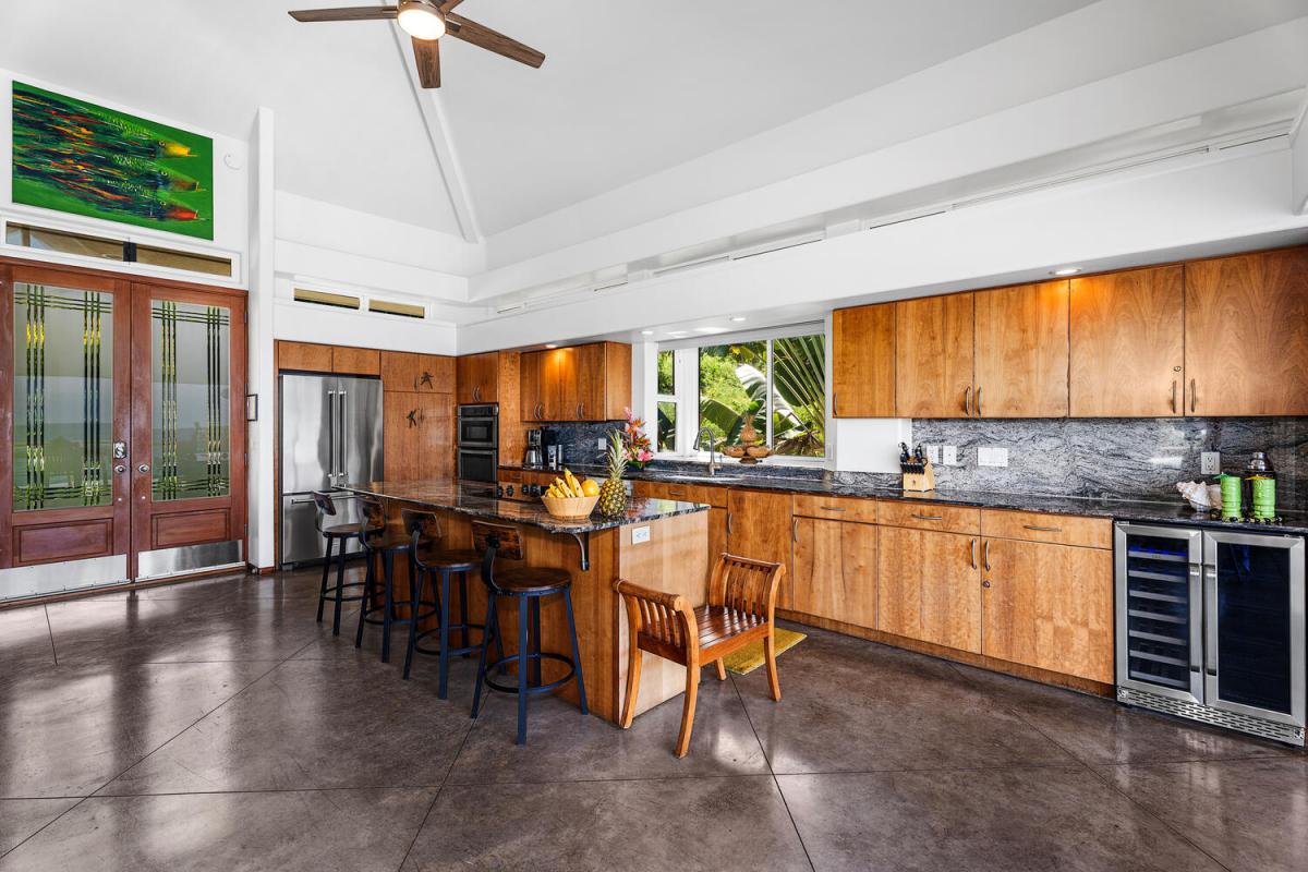 Spacious chef’s kitchen with island seating and seamless flow to oceanview dining.