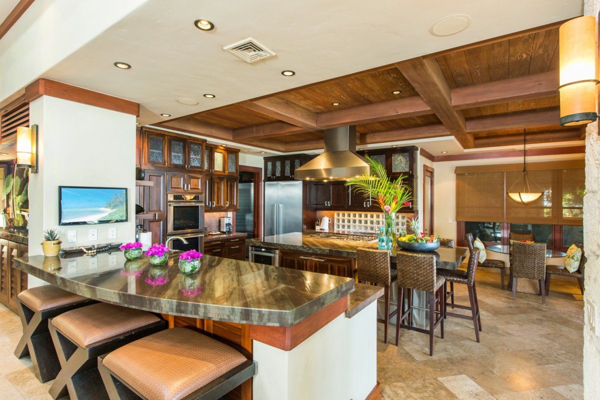 Kitchen view with island, counters, breakfast bar, and dining tables inside the Banyan House