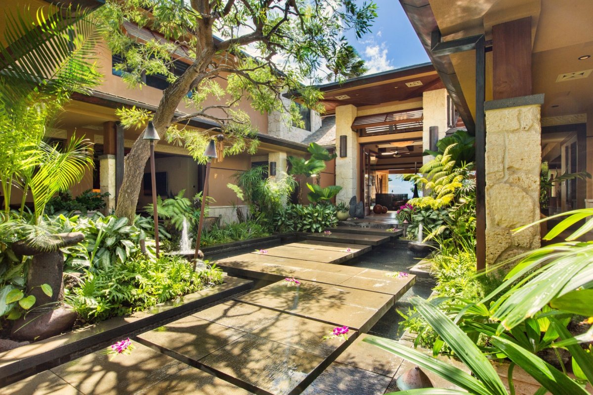 Over the pond pathway surrounded by lush greenery at Banyan House on Oahu