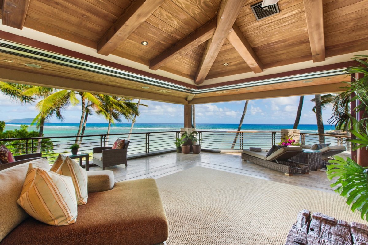 Primary bedroom with direct access to the terrace, ocean view, cushioned chaise lounges, and other seats on Oahu