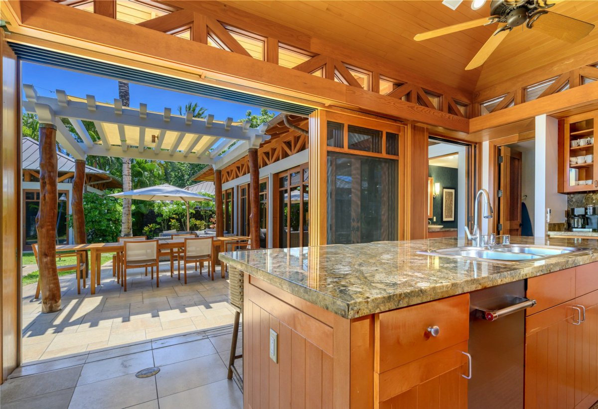 The island bar overlooking the outdoor lanai with umbrellas for a fun meal prep..