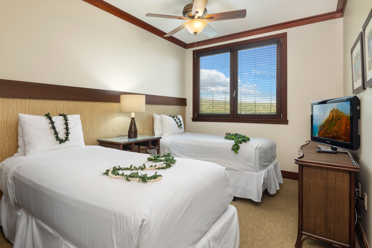 The third guest bedroom has twin beds with scenic views and tropical decor.