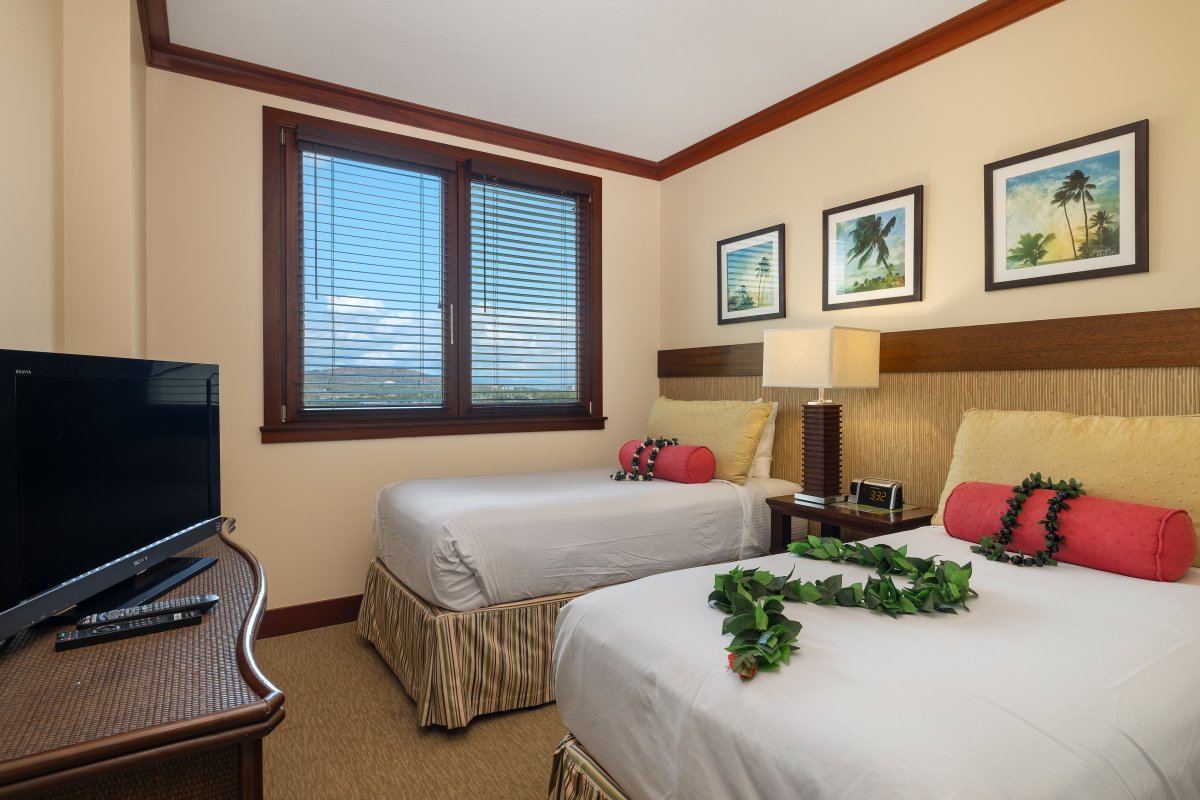 The second guest bedroom boasts colorful twin beds and island art.