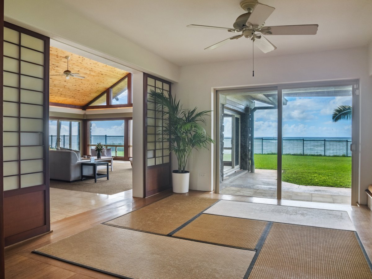 Open sliding doors invite you to a seamless indoor-outdoor living experience with ocean views.