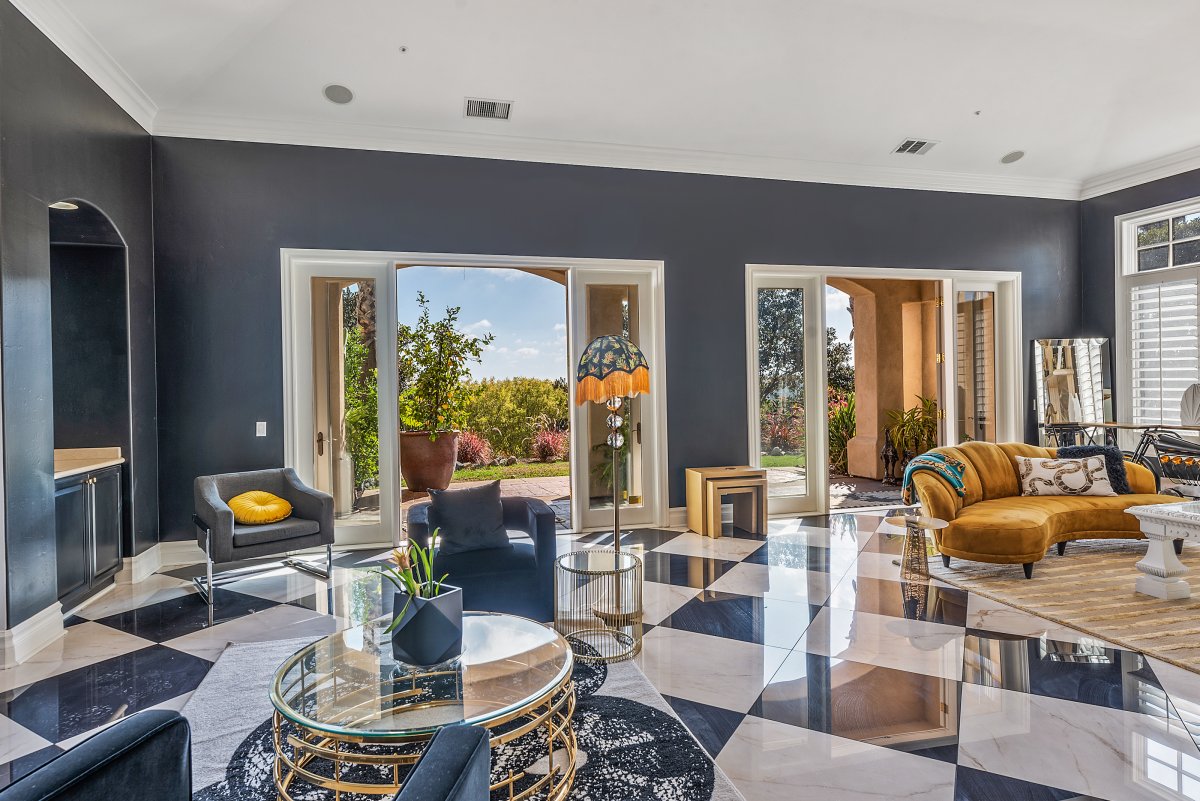 The "Grand Gatsby" with luxurious decor and flooring in dark grays, blues and oranges, floor to ceiling windows, French doors leading to the amazing back yard, stone fireplace and lots of natural light.