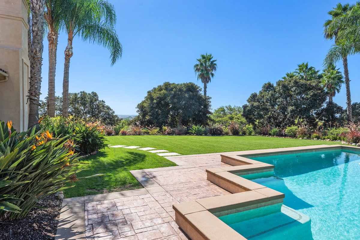 A serene escape awaits as you take a dip in our pool, surrounded by lush greenery and the gentle rustle of mature palms