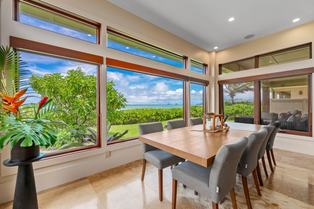 The modern dining area featuring a table for ten and 180-degree view of the ocean, including a view of the Mokuluas.