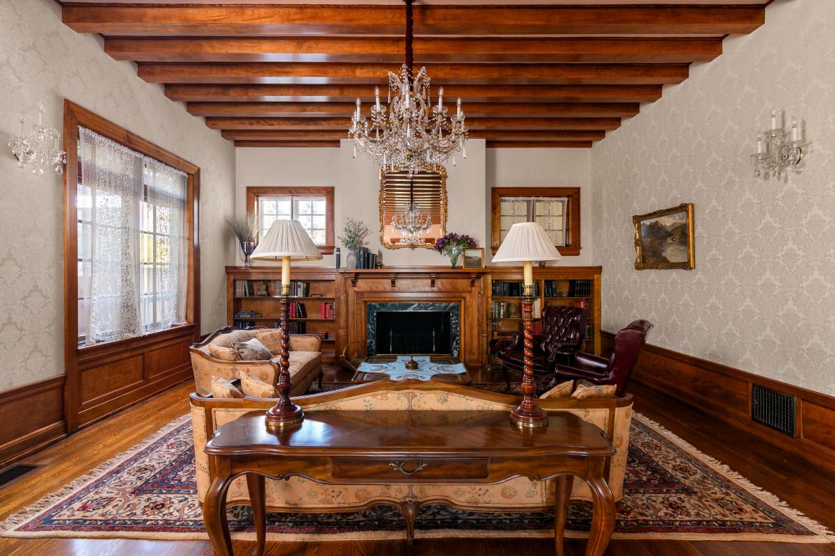 Relax in your elegant living room with exposed beams, crystal chandeliers, and a cozy fireplace perfect for quiet evenings.