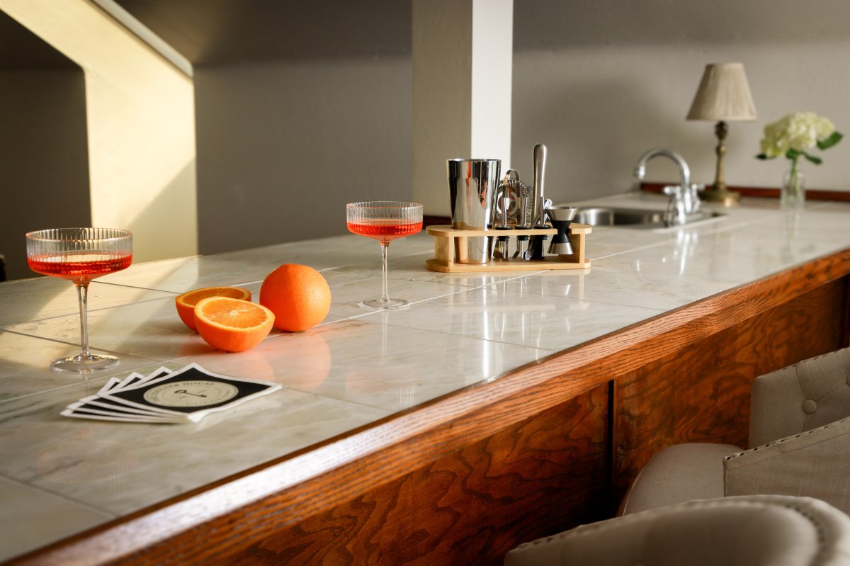 Wet bar with seating for four and entertainment space.