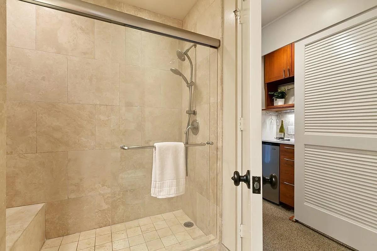Luxurious walk-in shower with modern fixtures and neutral-toned tile design. – Perfect for refreshing after a day of exploration.