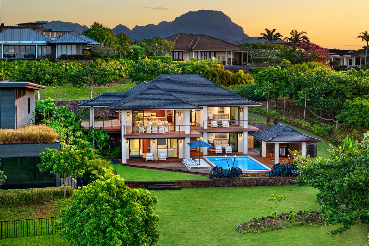 Sunset-lit aerial perspective of the home, highlighting lush surroundings.