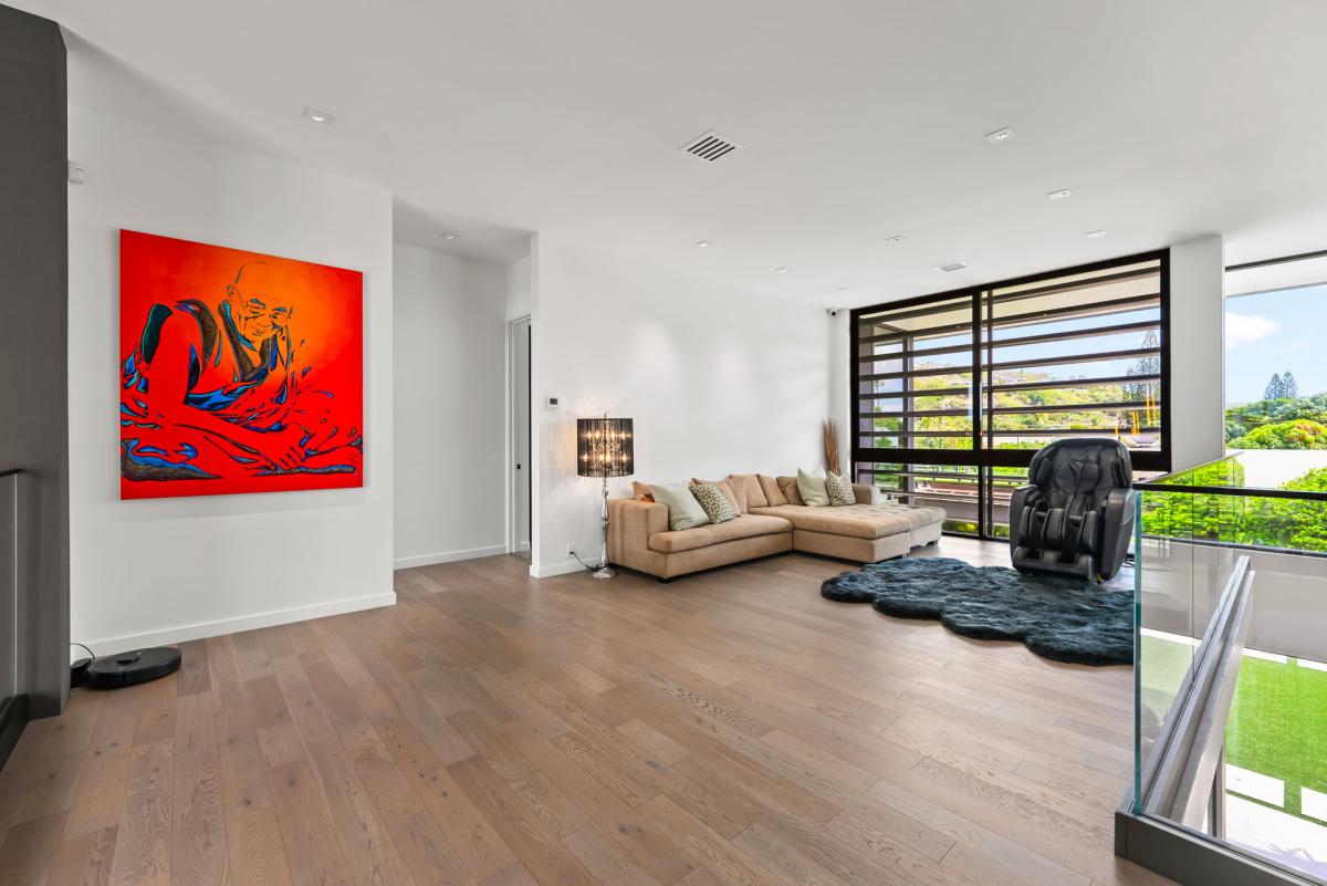 A cozy upstairs retreat perfect for reading, yoga, or quiet conversation—accented by rich wood flooring and bold artwork.