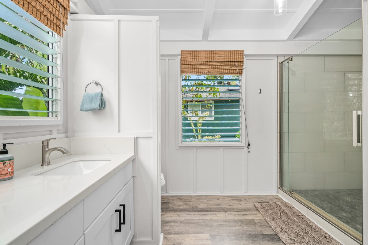 The walk-in shower faces a window of pure tropical green, glass and greenery and little else.