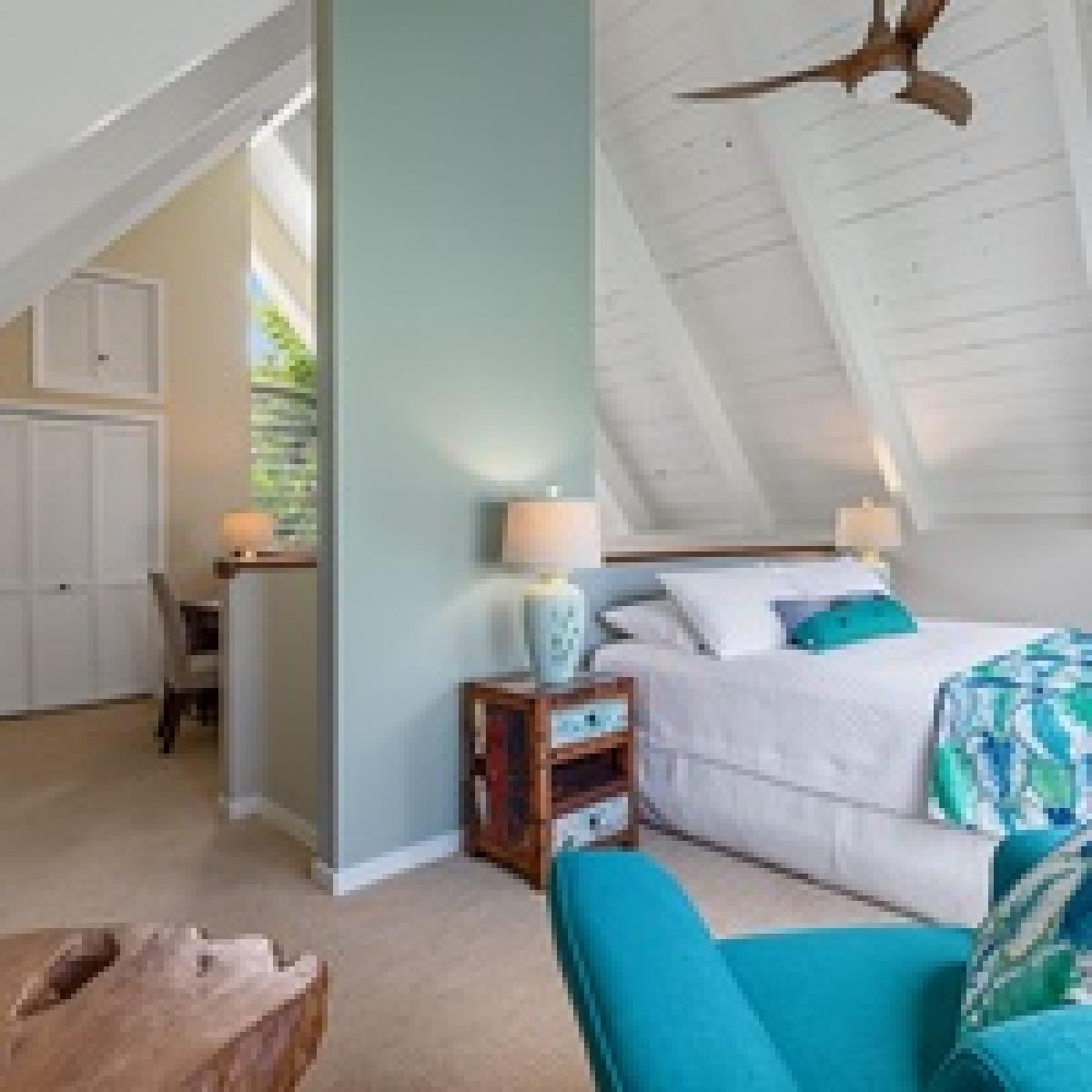 Pool house bedroom featuring a king-size bed and airy, coastal-inspired decor.