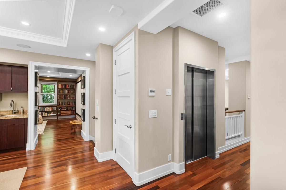 Spacious hallway with private elevator and hardwood flooring.