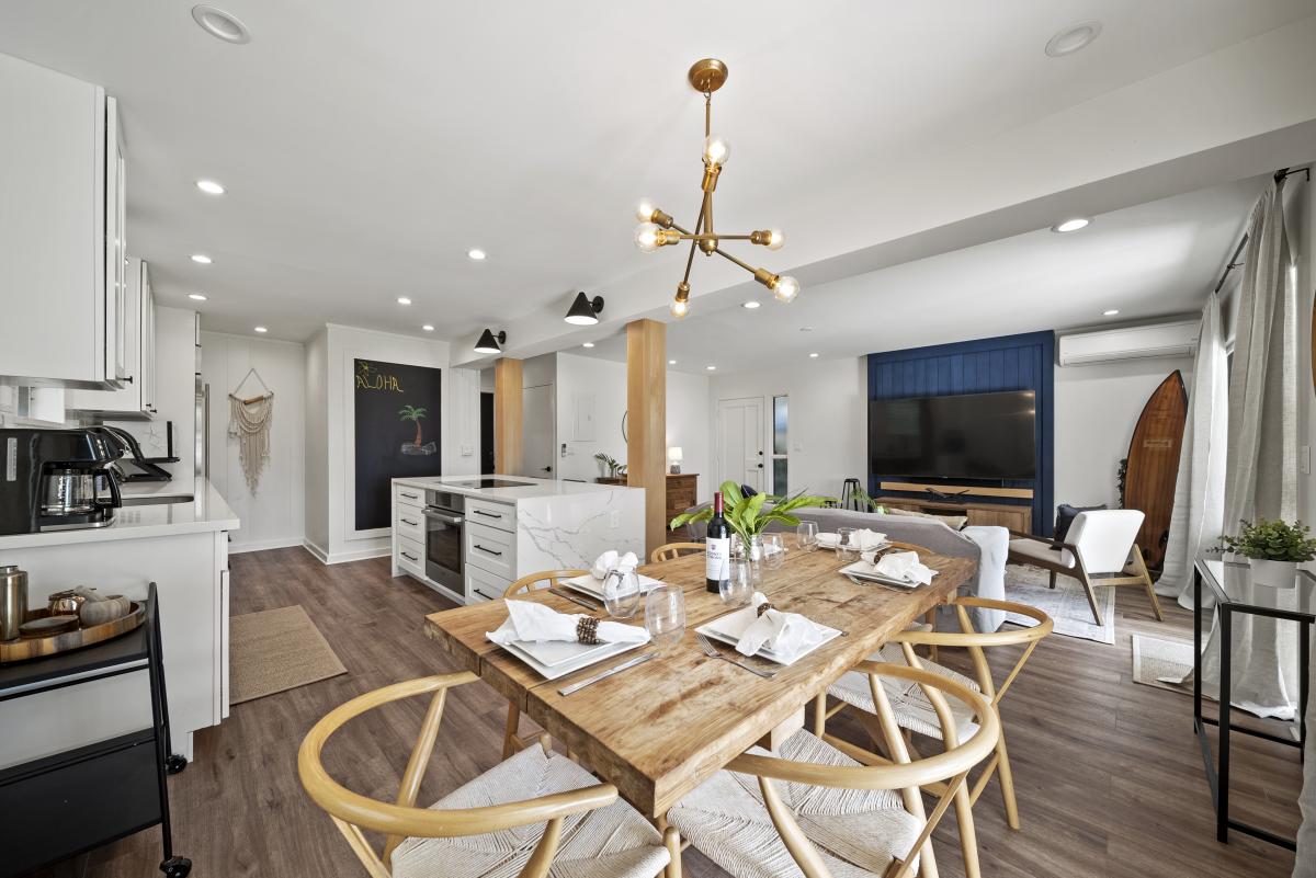 Elegant dining area seating six, surrounded by floor-to-ceiling windows showcasing tropical garden views — ideal for unforgettable meals.