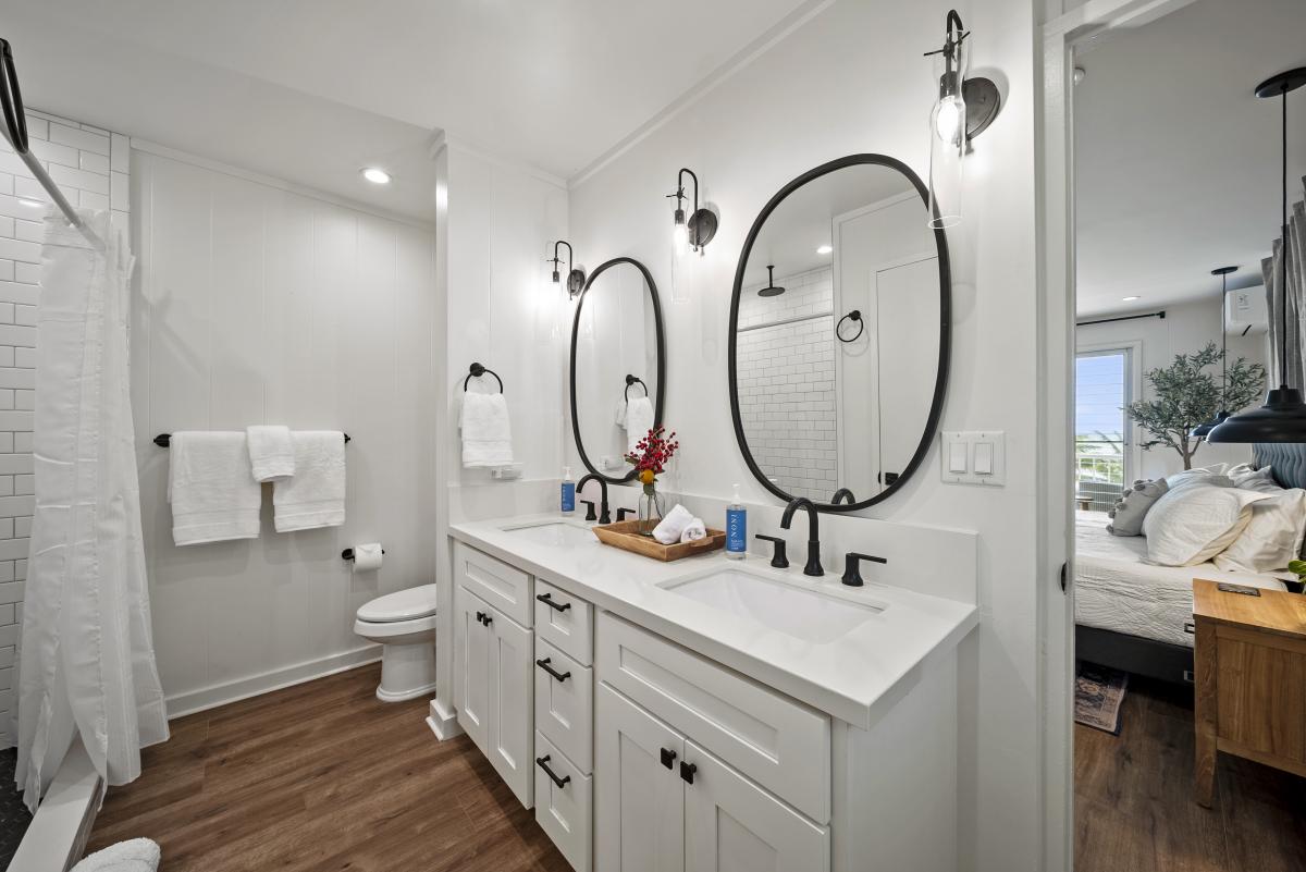 The ensuite has double vanity bathroom with round mirrors, modern lighting, and a spa-inspired design perfect for unwinding.