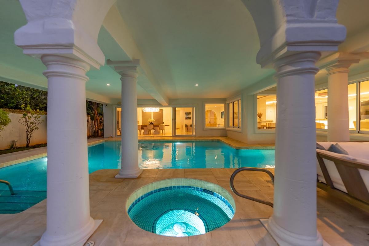 Indoor spa tub tucked under graceful columns, perfect for evening relaxation.