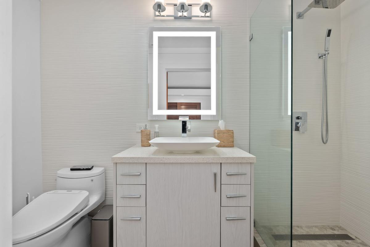 Another modern ensuite with chic finishes and warm tones—no detail overlooked at Honolulu Lagoonfront Retreat.