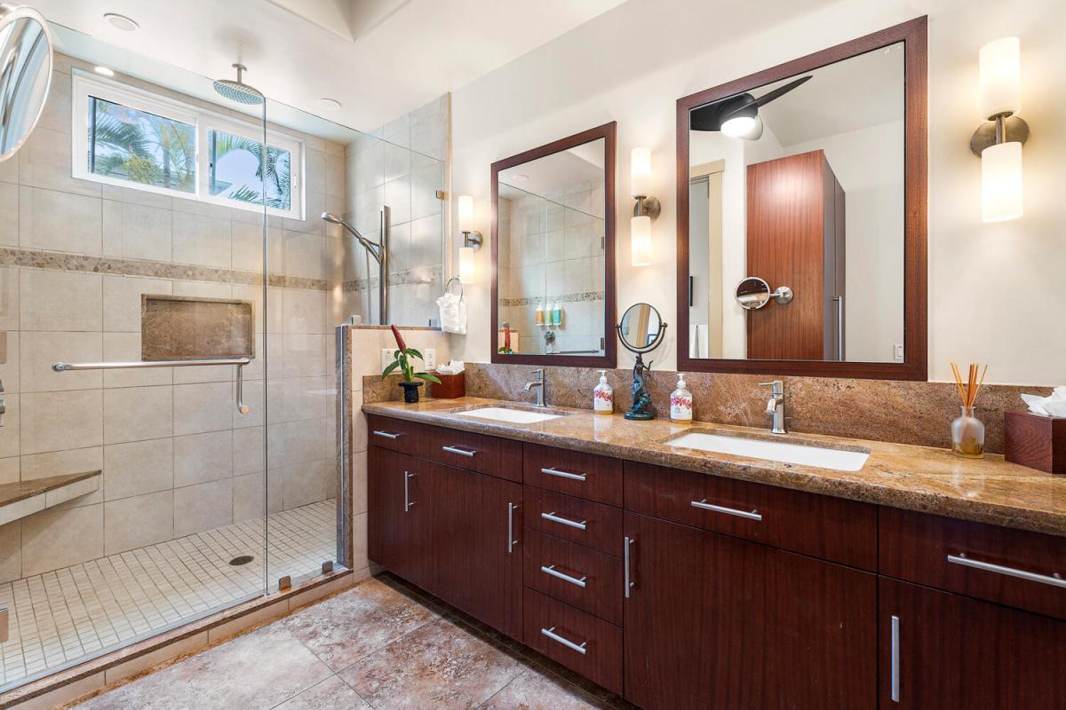 Travertine tile, rainfall glass shower, and twin sinks mean no one has to wait before the dinner reservation downtown.