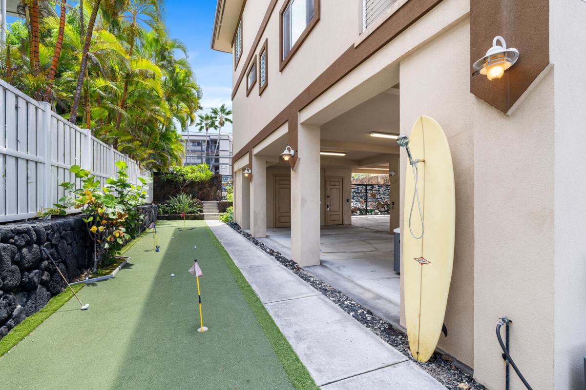 Tune up your short game beside custom surfboard outdoor shower and the shaded carport—perfect prep before tee time at nearby Kona Country Club.