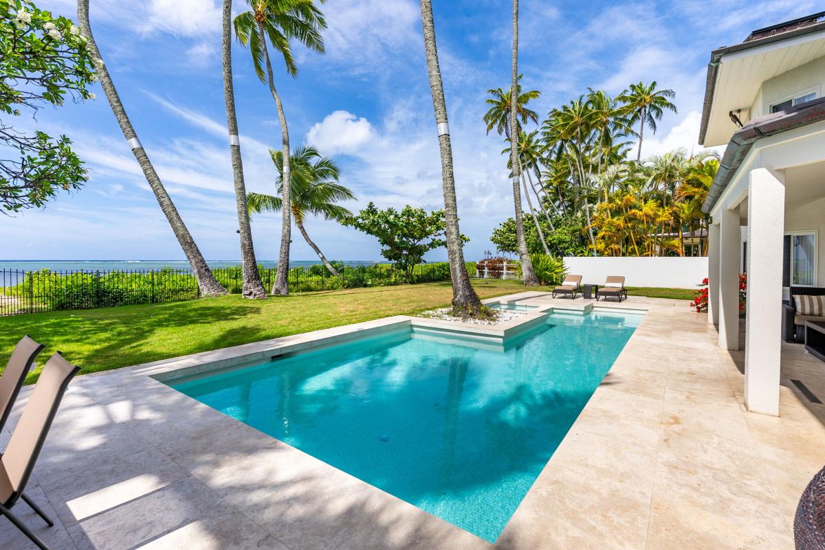 Soak up the sun or take a refreshing dip in the in-ground pool—framed by royal palms and beachfront views.